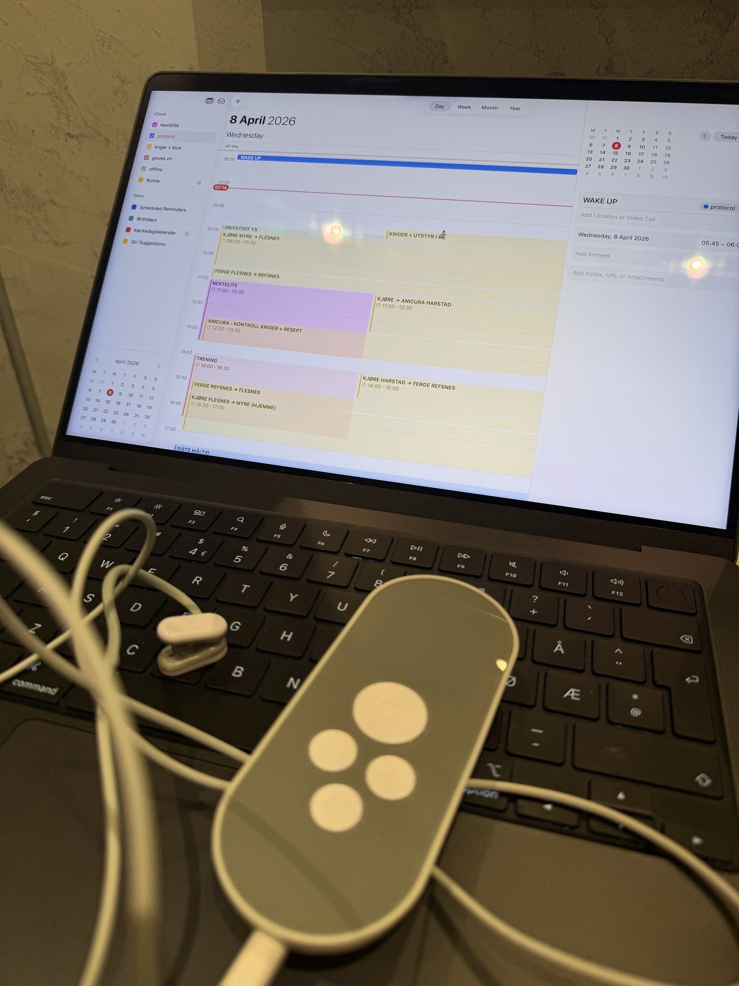 Laptop med kalender åpen på 8. april, Nurosym vagusnervstimulator med øreplugger ved siden av