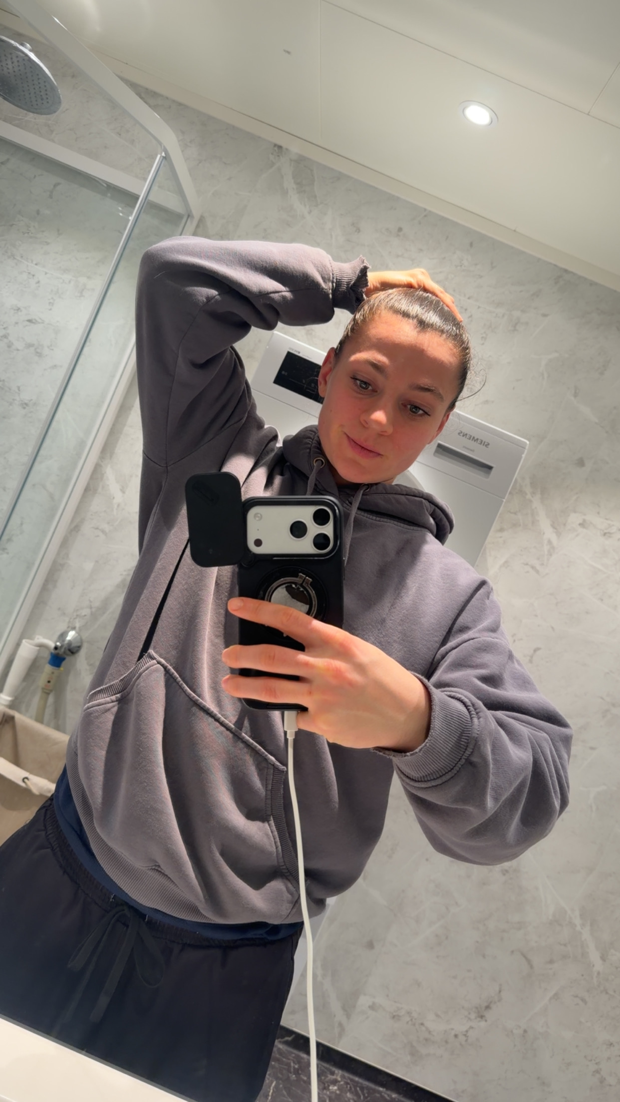 Speilbilde i badspeil, myk grå hoodie, morgenlys